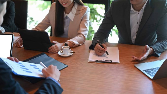 Group of business people discussing corporation project planning and business strategy together in boardroom.