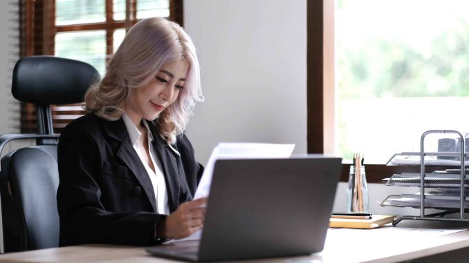 Smiling asian business woman sitting in a modern office.